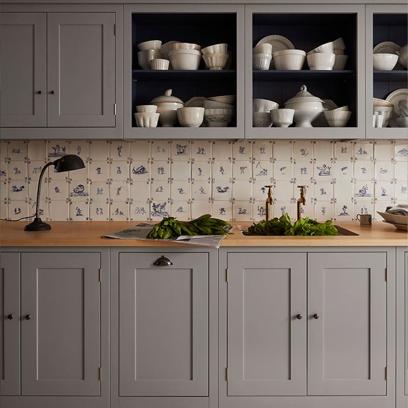 Grey painted wooden kitchen with vintage tiles